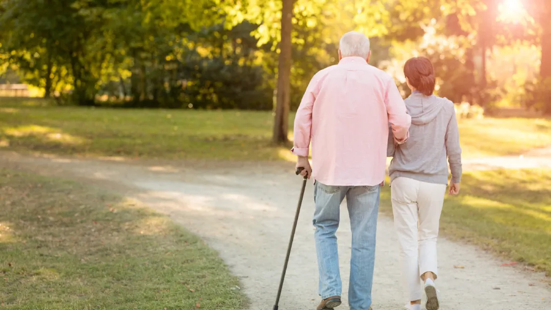 An older couple walking outdoors in the late afternoon
