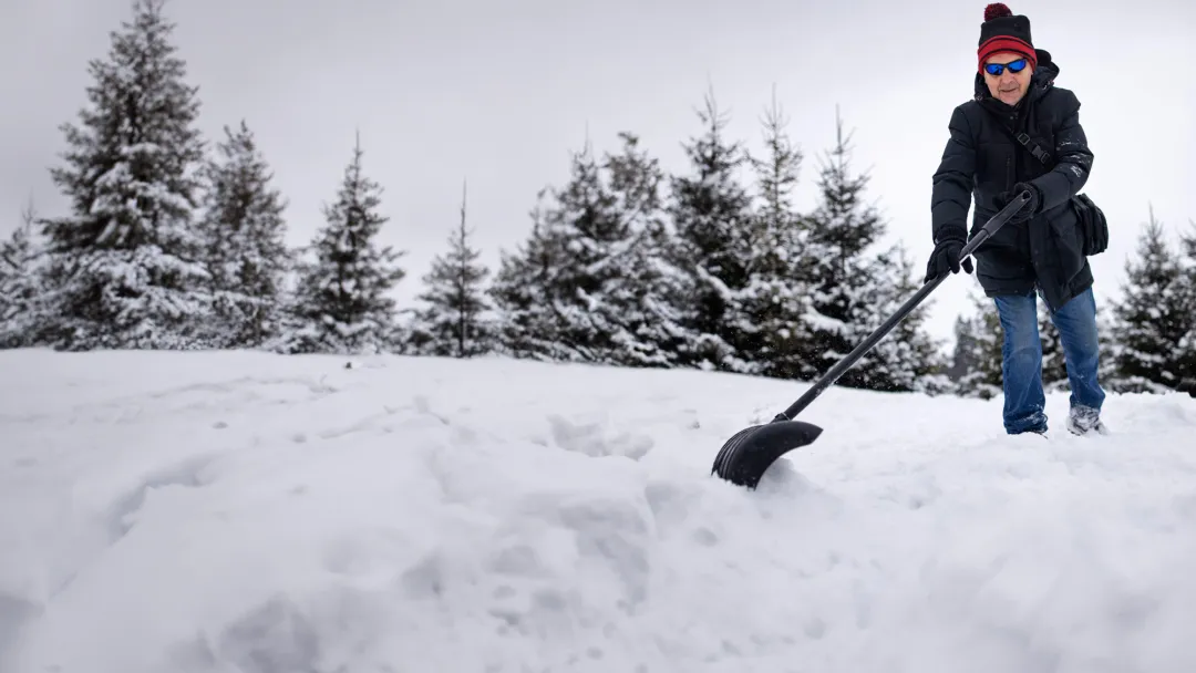 Man shoveling snow outdoors.