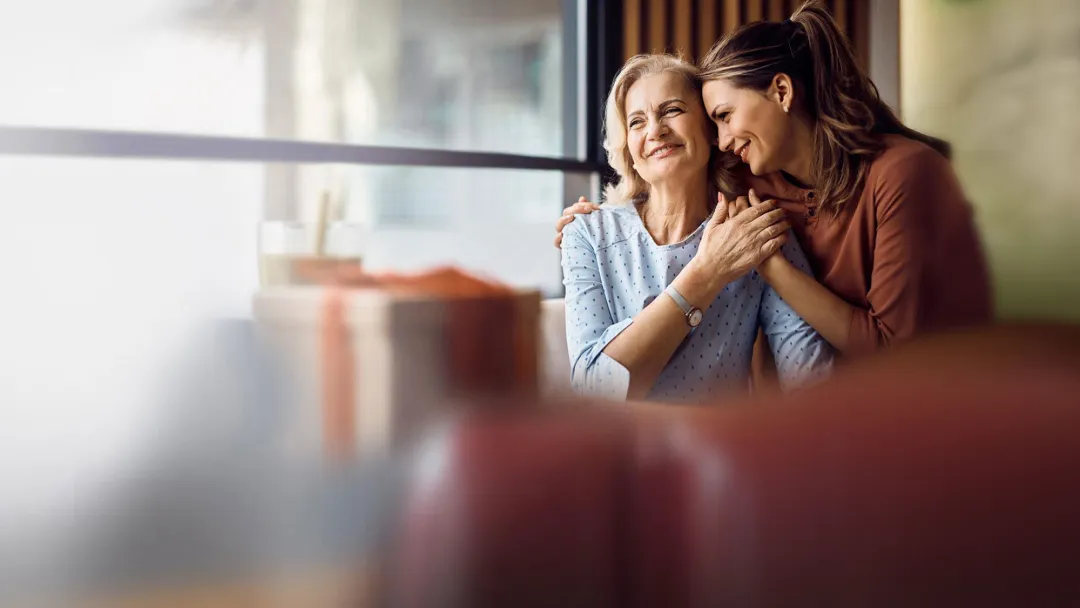 mother and daughter sitting at a table in a diner looking out the window