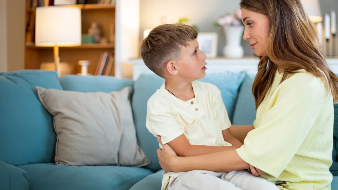 Mother Holding Son on Couch at Home 