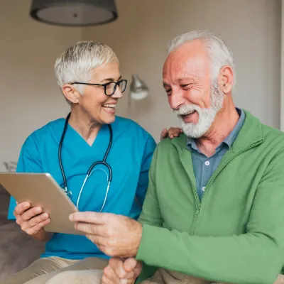 A Nurse Smiles as She Goes Over a Patient's Chart with Him