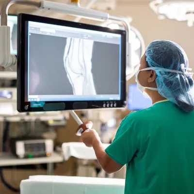 doctor in scrubs examining an x-ray in a surgical room