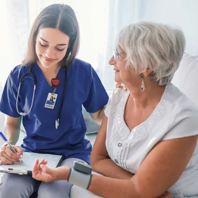 Nurse checking patient's blood pressure.