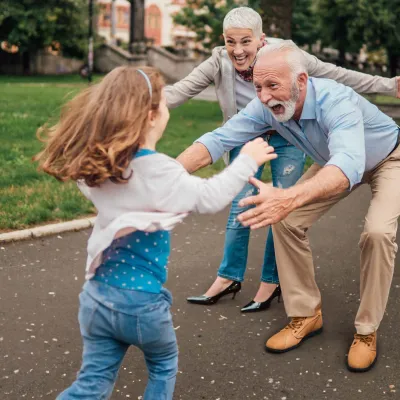 Grandparents greeting granddaughter in park