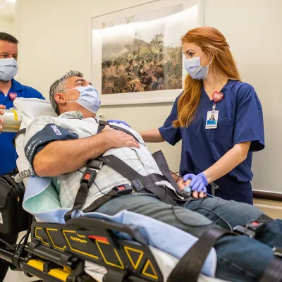 Patient in Stretcher Being Taken into ER Room