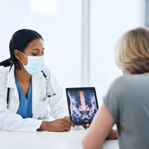  Doctor With Patient Showing X-rays