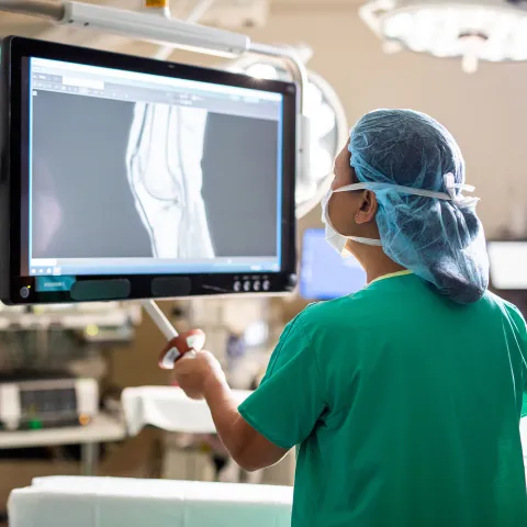 doctor in scrubs examining an x-ray in a surgical room