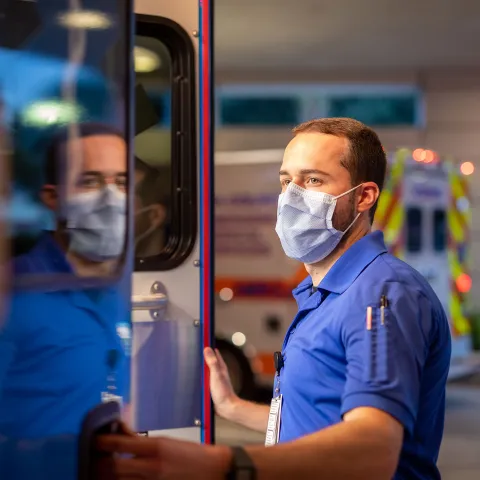 An EMT closing an ambulance door