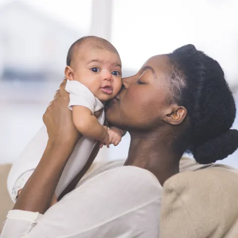 Mother Holding and Kissing Baby