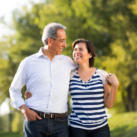Older couple walking outdoors smiling at each other