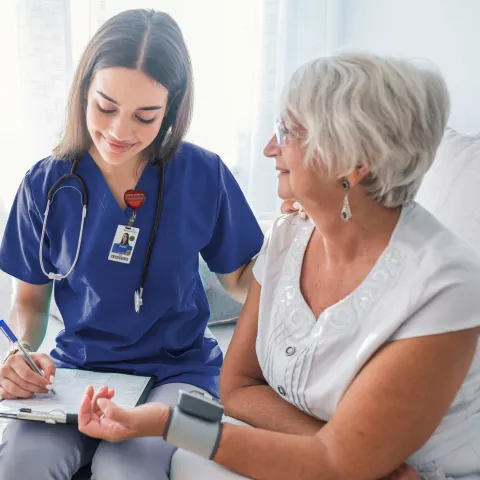 Nurse checking patient's blood pressure.