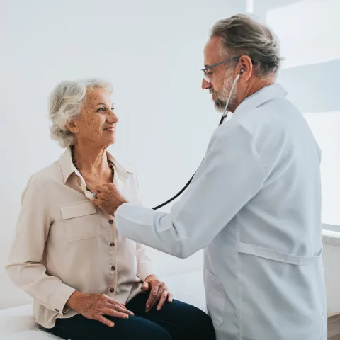 Older woman getting her heartbeat checked by a doctor.