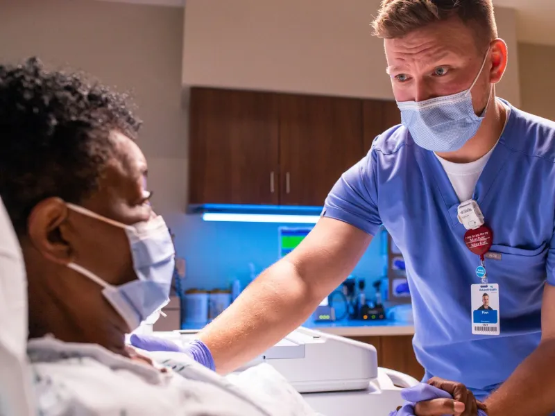 Nurse taking care of a woman in hospital bed