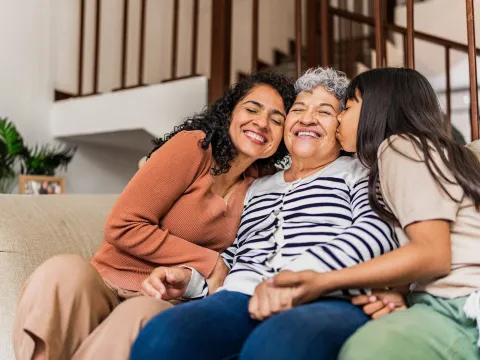 A multi-generational family sitting on the couch together.