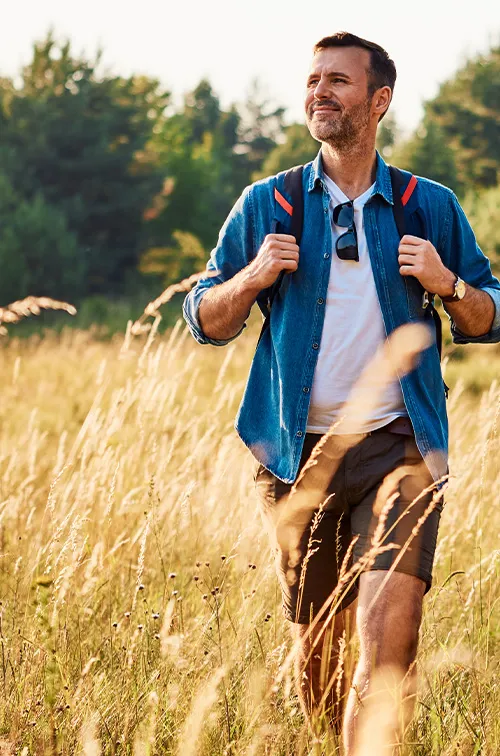 Man hiking with backpack on in fields