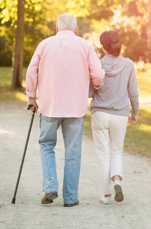 An older couple walking outdoors in the late afternoon