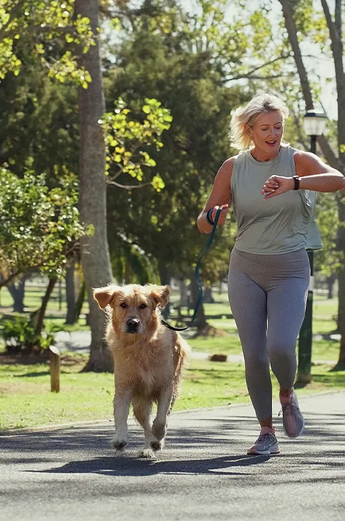 Woman Running With Dog Looking at Watch